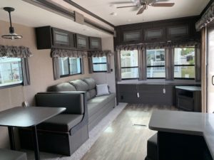 Inside of an RV with couch, table, and windows