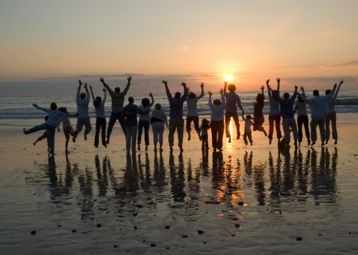 Group on the beach jumping for joy at sunset
